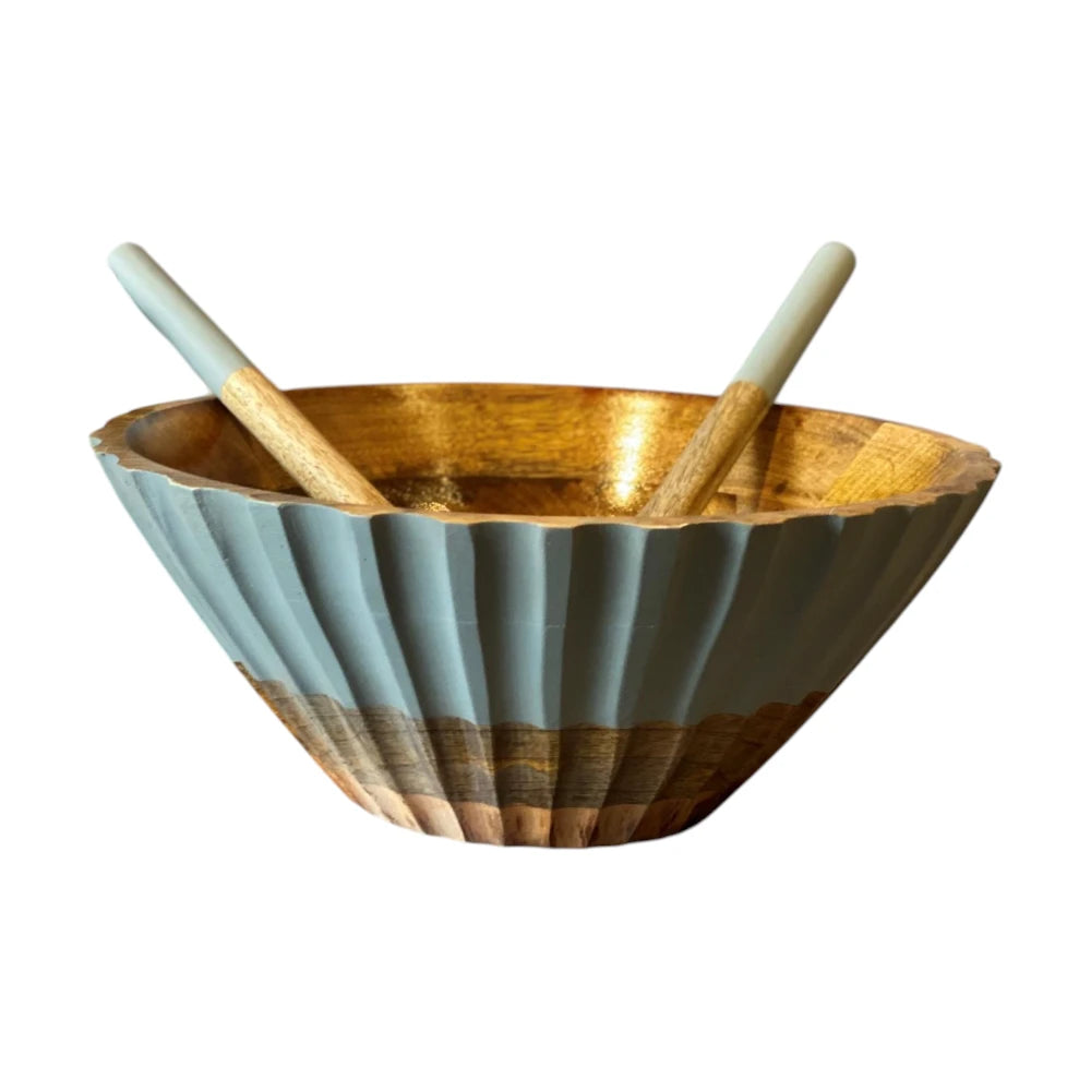 Decorative bowl with ribbed design and two wooden spoons on a white background